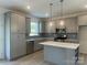Modern kitchen featuring gray cabinets, stainless steel appliances, and a center island at 411 Sunharvest Ln, Indian Trail, NC 28079