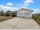 Ranch-style home with a large driveway and attached garage, set against a cloudy sky at 475 Union Baptist Church Rd, York, SC 29745