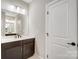 Modern bathroom featuring dark cabinets, white countertops, and a large mirror at 522 Fern Hill Rd # 17, Mooresville, NC 28117