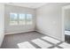 Bright bedroom featuring three windows overlooking a green lawn, carpeted floors, and neutral walls at 522 Fern Hill Rd # 17, Mooresville, NC 28117