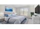 Serene bedroom featuring a plush bed, stylish decor, a large window, and tranquil blue artwork at 522 Fern Hill Rd # 17, Mooresville, NC 28117