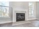 Cozy fireplace featuring decorative molding, neutral tile surround, and large windows on either side at 522 Fern Hill Rd # 17, Mooresville, NC 28117