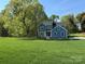 Beautiful two-story home with a large, green front yard and surrounded by mature trees at 522 Fern Hill Rd # 17, Mooresville, NC 28117