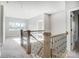 Open hallway with wrought iron railing leading to a sunlit living space with large windows at 522 Fern Hill Rd # 17, Mooresville, NC 28117