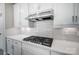 Close-up of a modern gas cooktop and range hood in a white kitchen at 522 Fern Hill Rd # 17, Mooresville, NC 28117