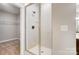 Modern walk-in shower with white tiles and glass door next to an open doorway for closet space at 522 Fern Hill Rd # 17, Mooresville, NC 28117