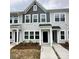 Stylish townhouse with gray and white exterior, front porch, and landscaping at 5821 Tuckaseegee Rd # 12, Charlotte, NC 28208
