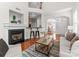 Open-concept living room with fireplace, hardwood floors and bar seating at 5980 Pale Moss Ln, Charlotte, NC 28269