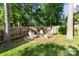 Outdoor space with a fire pit and chairs nestled in a fenced yard with mature trees at 6210 Skyline Dr, Charlotte, NC 28269