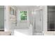 Clean bathroom with soaking tub, shower, and window with view of mature trees at 6210 Skyline Dr, Charlotte, NC 28269