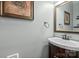 Cozy half bathroom featuring a vanity sink, mirror, and decorative artwork at 6210 Skyline Dr, Charlotte, NC 28269