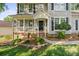 Close up view of a home's covered entrance and front porch with manicured landscaping and walkway at 6210 Skyline Dr, Charlotte, NC 28269