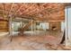 Large unfinished basement featuring a staircase, fireplace, and exposed ceiling at 624 Flicker St, Concord, NC 28027
