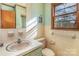 Modest bathroom featuring a single sink, tile accents, and a window for natural light at 624 Flicker St, Concord, NC 28027