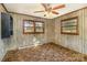 Bedroom featuring paneled walls, two windows, carpet, ceiling fan, and dark wood trim at 624 Flicker St, Concord, NC 28027