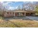 Charming single-story brick home with a covered front porch and a connected carport with a well-maintained lawn at 624 Flicker St, Concord, NC 28027