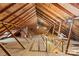 Unfinished attic with exposed wooden beams, rafters, and a small staircase at 719 N Fulton St, Salisbury, NC 28144