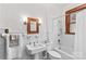 Bathroom featuring white tile walls, white fixtures and a window with wooden trim at 719 N Fulton St, Salisbury, NC 28144