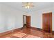Bedroom featuring hardwood floors, wooden trim, multiple entryways and a ceiling fan at 719 N Fulton St, Salisbury, NC 28144