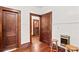 A hallway with dark wood floors, three doors, and a stool at 719 N Fulton St, Salisbury, NC 28144