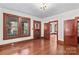 Living room with hardwood floors, large windows, wooden trim and a doorway leading to another room at 719 N Fulton St, Salisbury, NC 28144