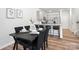 Elegant dining area with black table set, hardwood floors, and a modern kitchen backdrop at 722 Herlong Ave, Rock Hill, SC 29732