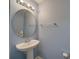 Cozy half bathroom with a pedestal sink, round mirror, and neutral walls at 746 Elders Story Rd, Fort Mill, SC 29708