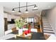 Open floor plan showcasing the modern kitchen flowing into the dining and living areas with a staircase at 8034 Cedarsmith Ct, Charlotte, NC 28217