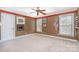 A cozy bedroom with neutral carpet, ceiling fan, and window views showcases comfort and a calm ambiance at 8704 Dartmoor Pl, Mint Hill, NC 28227