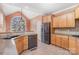 Bright kitchen with stainless steel appliances, wooden cabinetry, and an arched window offering plenty of natural light at 8704 Dartmoor Pl, Mint Hill, NC 28227