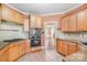 Cozy kitchen featuring classic wood cabinets, tile backsplash, and modern appliances, perfect for culinary enthusiasts at 8704 Dartmoor Pl, Mint Hill, NC 28227