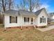 Charming one-story home with white siding, black shutters, covered front porch, and well-maintained landscaping at 89 Fifth St, York, SC 29745