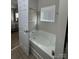 Bright bathroom featuring a soaking tub with tile surround and natural light from the window at 905 Roxburgh Ave, Rock Hill, SC 29732