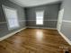 Empty bedroom with wood floors and natural light from two windows at 915 Spruce St, Albemarle, NC 28001