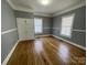 Bright bedroom featuring wood floors, neutral walls, and a closet between two windows at 915 Spruce St, Albemarle, NC 28001