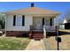 Charming single-story home featuring a cozy front porch, brick foundation, and well-maintained yard at 915 Spruce St, Albemarle, NC 28001