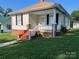 Charming home featuring a cozy front porch with brick accents and manicured lawn at 915 Spruce St, Albemarle, NC 28001
