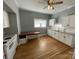 Well-lit kitchen featuring white cabinets, wood floors, and a dining area with a dark wood table at 915 Spruce St, Albemarle, NC 28001