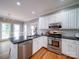 Modern kitchen with stainless steel appliances, white cabinets, and a large countertop at 915 Waterview Ln, Monroe, NC 28110