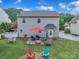 Aerial view of a backyard with a patio set, grill, fire pit, and lush green lawn enclosed by a white fence at 1017 Chalk Hill Ln, Charlotte, NC 28214