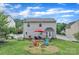 Spacious backyard with a stone patio, comfortable seating, a red umbrella, and a fire pit for outdoor enjoyment at 1017 Chalk Hill Ln, Charlotte, NC 28214