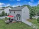 Beautiful backyard featuring a patio with outdoor seating, a red umbrella, and a well-manicured lawn at 1017 Chalk Hill Ln, Charlotte, NC 28214