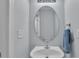Powder room featuring a pedestal sink, oval mirror, and light blue walls at 1017 Chalk Hill Ln, Charlotte, NC 28214