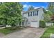 Charming two-story home featuring blue shutters and a well-maintained front yard with mature trees at 1017 Chalk Hill Ln, Charlotte, NC 28214