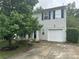 Two-story home with vinyl siding, blue shutters, a single-car garage, and mature landscaping at 1017 Chalk Hill Ln, Charlotte, NC 28214