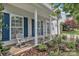 Inviting front porch with white columns, blue shutters, seating and beautiful landscaping at 1017 Chalk Hill Ln, Charlotte, NC 28214