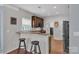 Open kitchen with granite countertops, breakfast bar and dark cabinetry and stainless refrigerator at 1017 Chalk Hill Ln, Charlotte, NC 28214