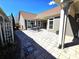 Stone patio with outdoor seating connects the house to a covered porch and landscaped yard at 1112 Avalon Pl, Stallings, NC 28104