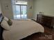 This bedroom features wood floors, closet access, and sliding glass door access to the backyard at 1112 Avalon Pl, Stallings, NC 28104