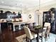 Stylish dining area with dark wood table, chandelier, flows into kitchen with granite counters at 1112 Avalon Pl, Stallings, NC 28104